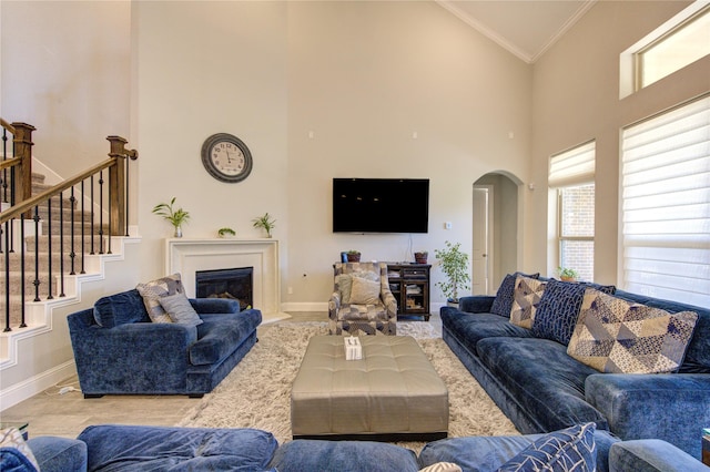 living room featuring crown molding and high vaulted ceiling