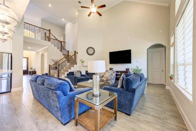 living room featuring a healthy amount of sunlight, light wood-type flooring, and a high ceiling