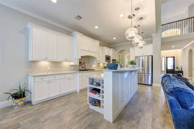 kitchen featuring pendant lighting, light wood-type flooring, stainless steel appliances, and white cabinetry