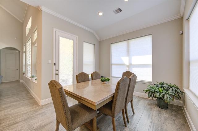 dining area with light hardwood / wood-style flooring, a wealth of natural light, and ornamental molding