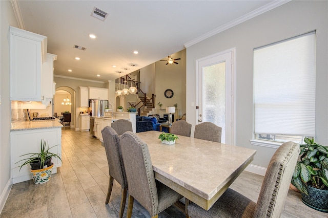 dining room featuring ceiling fan, ornamental molding, and light hardwood / wood-style flooring