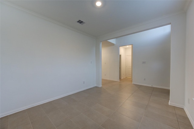 tiled spare room featuring ornamental molding