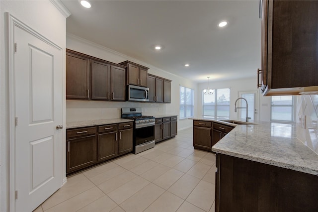 kitchen featuring crown molding, sink, hanging light fixtures, light stone countertops, and stainless steel appliances