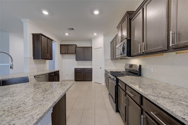 kitchen featuring sink, crown molding, light stone counters, dark brown cabinetry, and stainless steel appliances