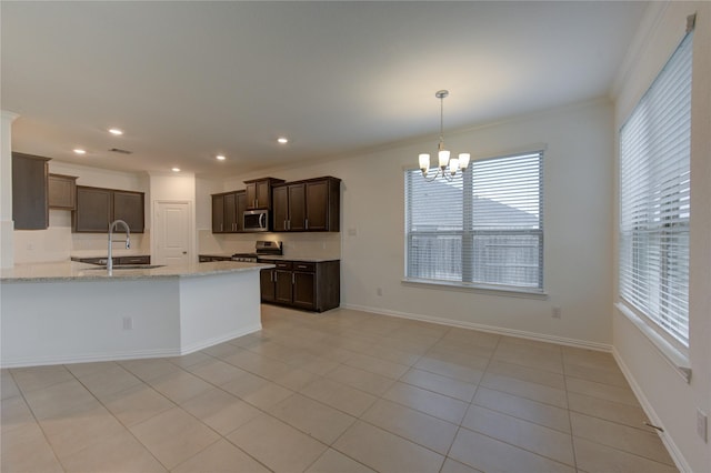 kitchen featuring light stone counters, dark brown cabinets, stainless steel appliances, sink, and light tile patterned floors