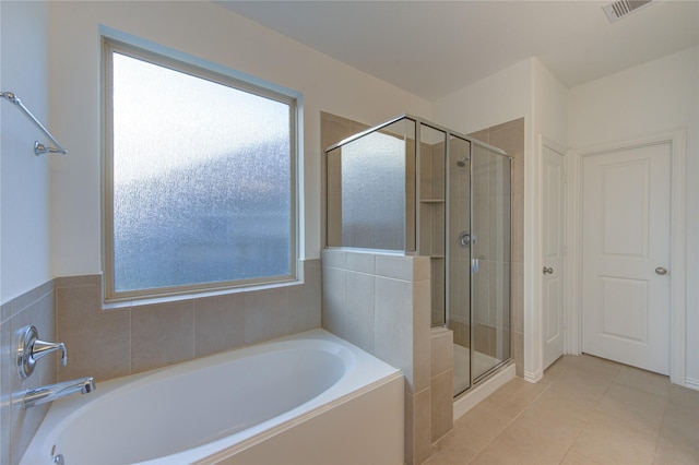 bathroom featuring tile patterned flooring and shower with separate bathtub