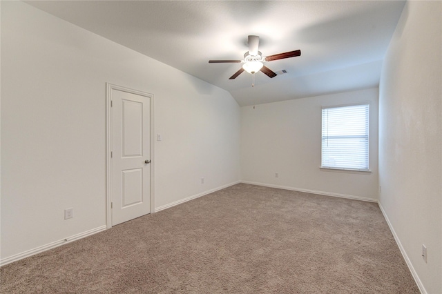 carpeted empty room featuring ceiling fan and vaulted ceiling