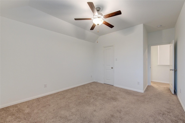 unfurnished bedroom featuring ceiling fan, light carpet, and vaulted ceiling