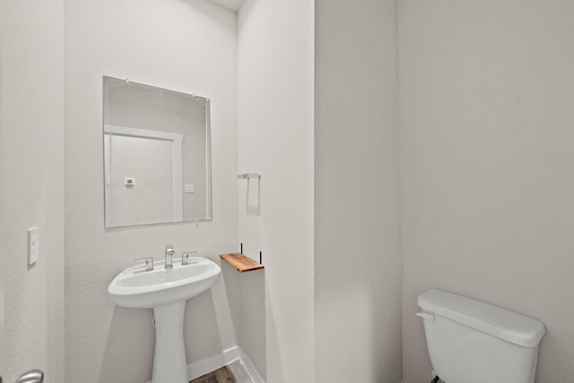 bathroom with hardwood / wood-style flooring, sink, and toilet