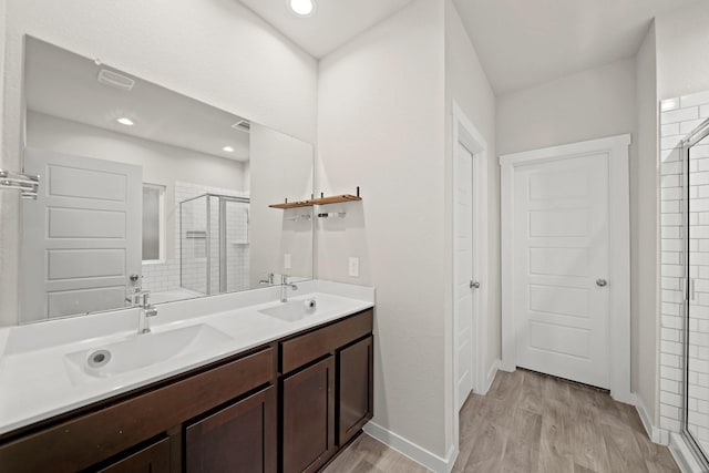 bathroom featuring vanity, hardwood / wood-style flooring, and a shower with shower door