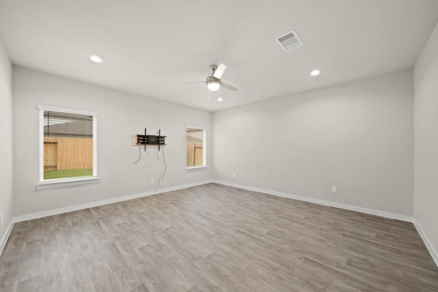 empty room with ceiling fan and light hardwood / wood-style floors