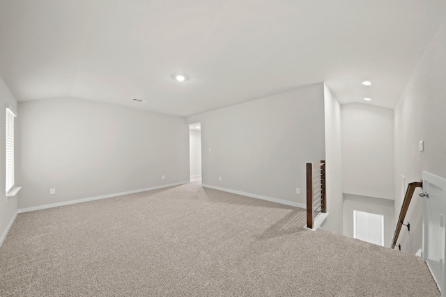 carpeted empty room featuring lofted ceiling