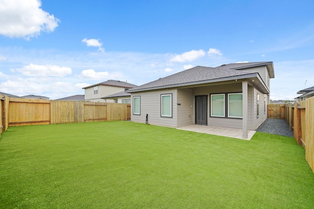 rear view of property featuring a yard and a patio