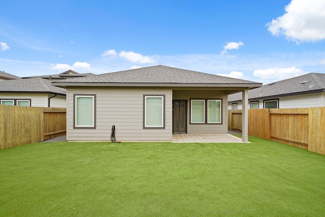 rear view of house with a lawn and a patio