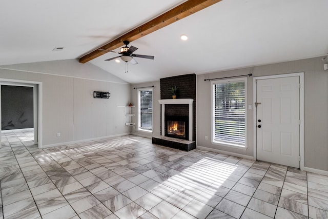 unfurnished living room with ceiling fan, lofted ceiling with beams, and a brick fireplace