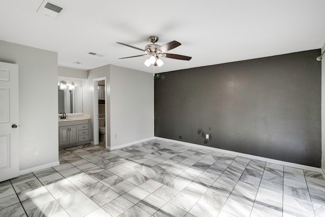 unfurnished bedroom featuring ensuite bath, ceiling fan, and sink