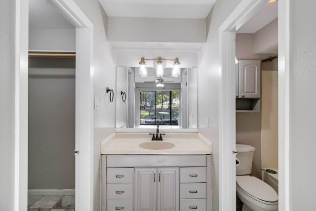 bathroom with vanity, toilet, and ceiling fan