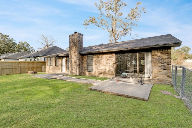 back of house with a patio area and a lawn