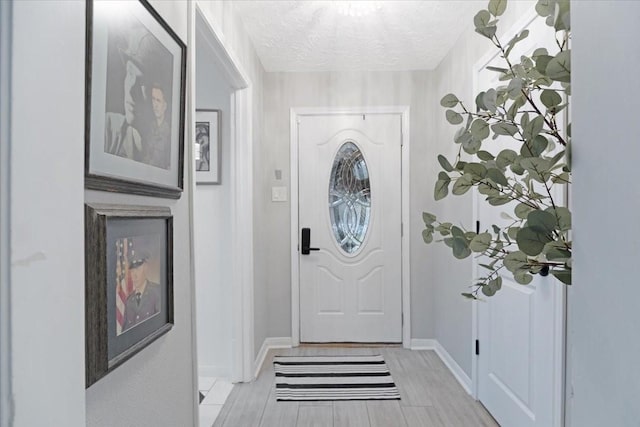 entryway featuring light hardwood / wood-style flooring and a textured ceiling