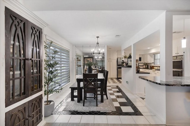 tiled dining space featuring a notable chandelier