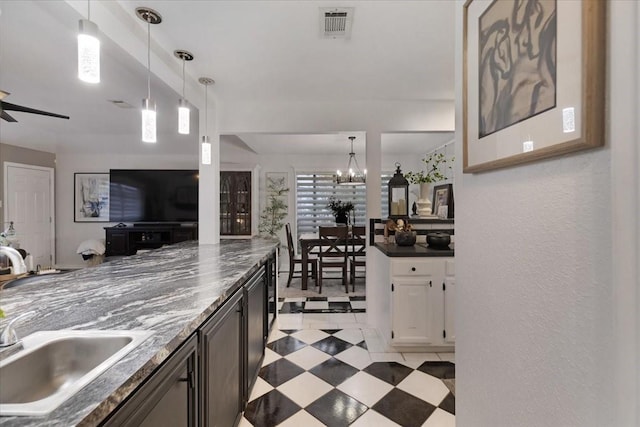 kitchen featuring decorative light fixtures, sink, and ceiling fan with notable chandelier