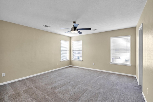 carpeted spare room featuring ceiling fan and a textured ceiling