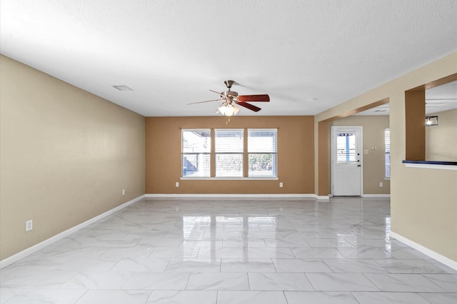 interior space with ceiling fan and a textured ceiling