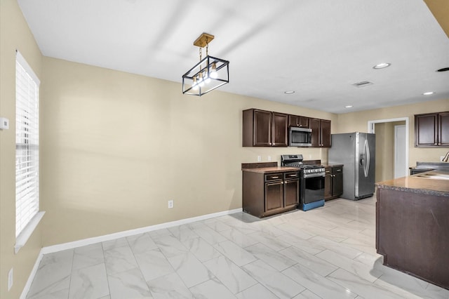 kitchen with a wealth of natural light, hanging light fixtures, stainless steel appliances, and dark brown cabinets