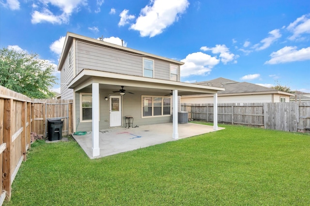 rear view of house with central air condition unit, ceiling fan, a lawn, and a patio