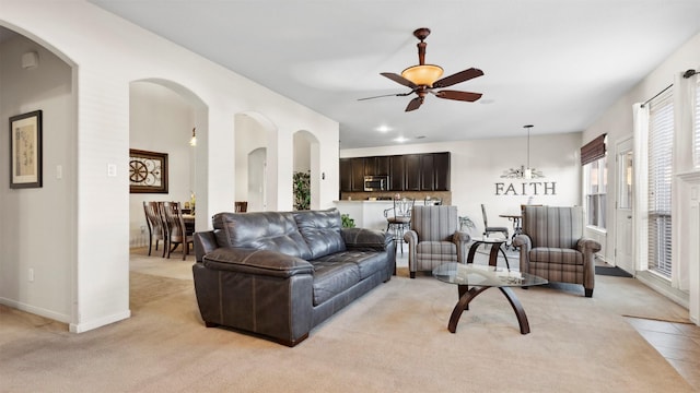 carpeted living room featuring ceiling fan