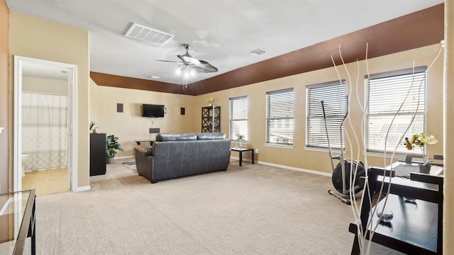 carpeted living room with ceiling fan