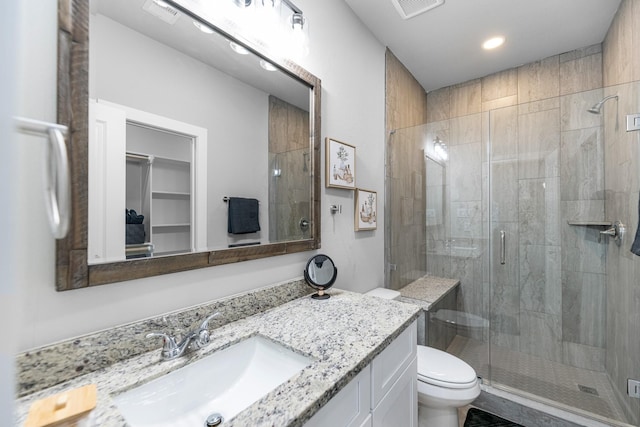 bathroom featuring vanity, toilet, and an enclosed shower