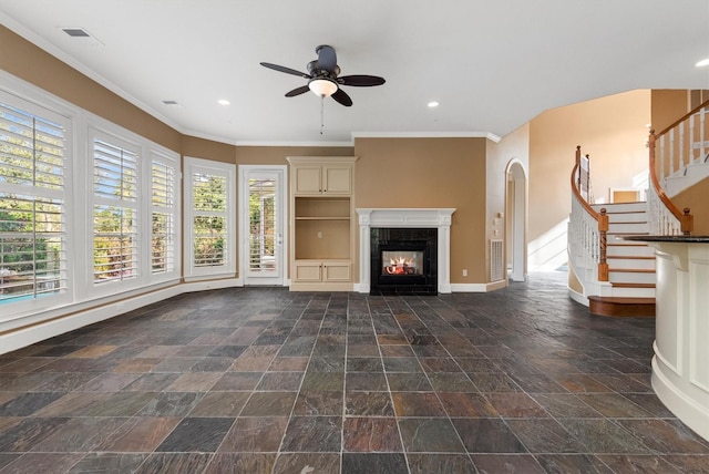 unfurnished living room featuring ceiling fan, crown molding, and a tile fireplace