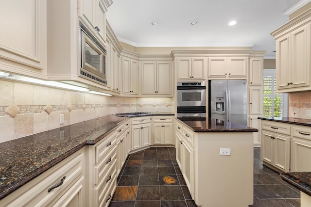 kitchen with crown molding, stainless steel appliances, and cream cabinets