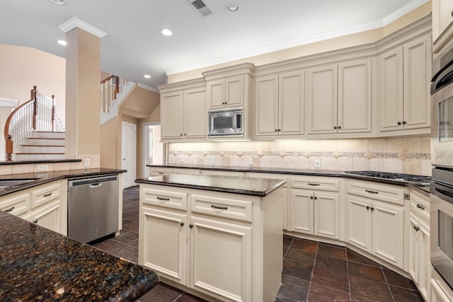 kitchen featuring tasteful backsplash, cream cabinetry, and appliances with stainless steel finishes