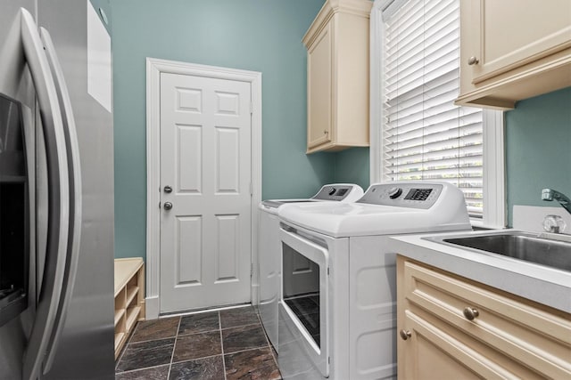 washroom with washing machine and clothes dryer, sink, and cabinets