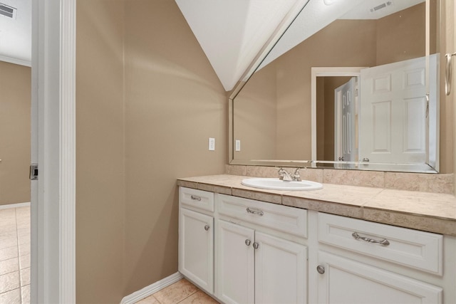 bathroom with tile patterned floors, vanity, and lofted ceiling