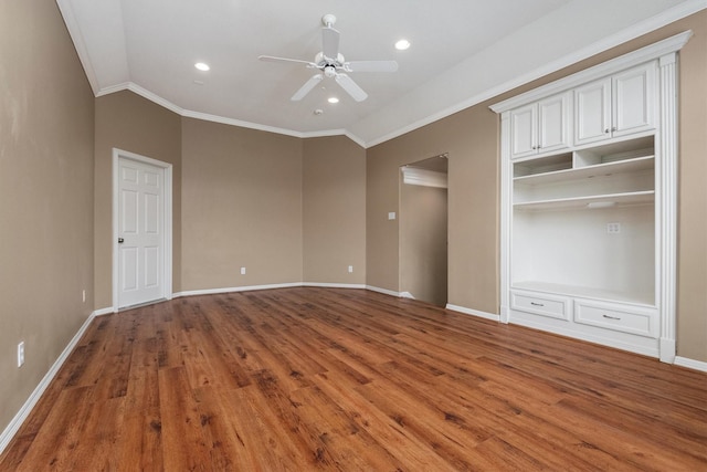 unfurnished bedroom with hardwood / wood-style flooring, ceiling fan, crown molding, and a closet