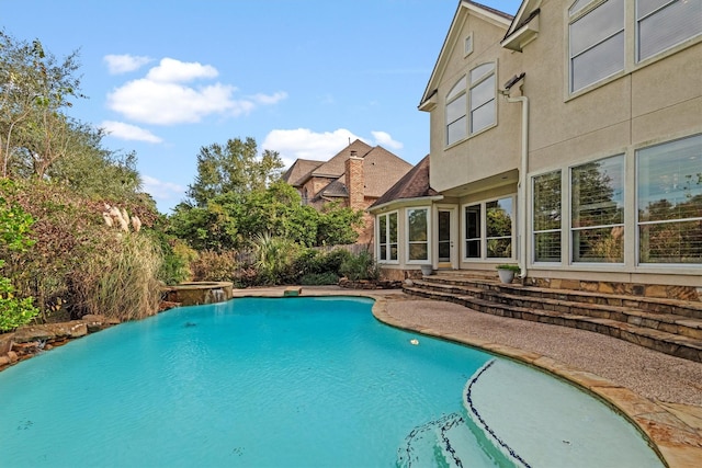 view of swimming pool featuring a hot tub