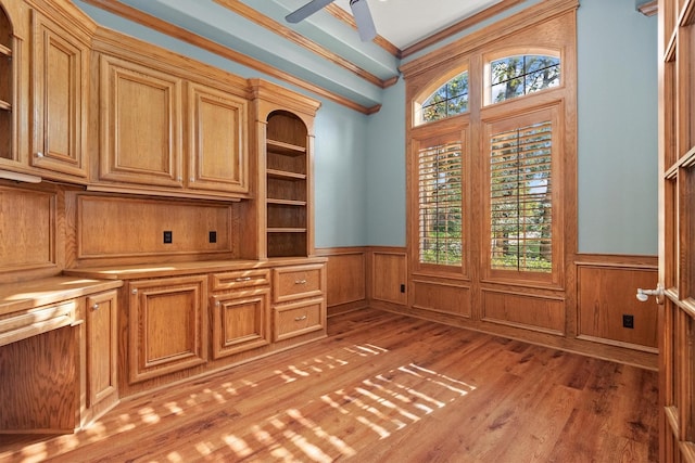 unfurnished office featuring hardwood / wood-style floors, ceiling fan, and crown molding