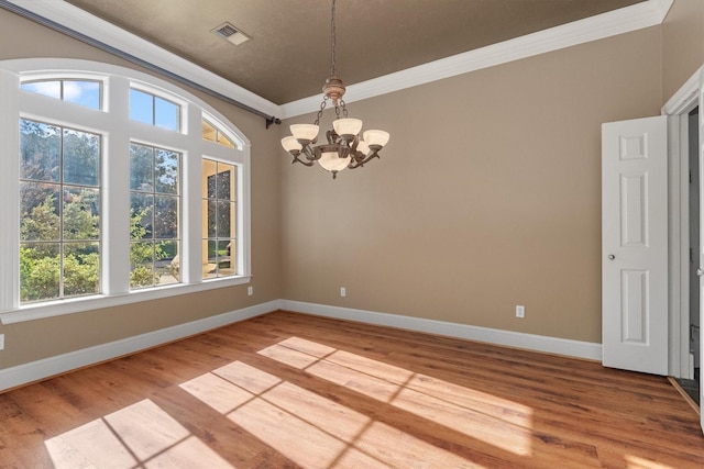 unfurnished dining area with wood-type flooring, ornamental molding, and a chandelier