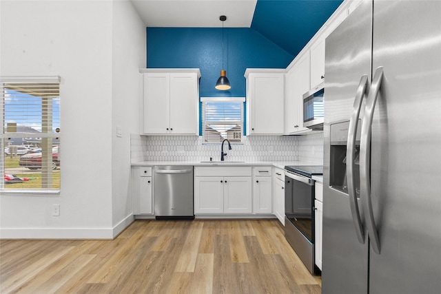 kitchen featuring pendant lighting, white cabinetry, stainless steel appliances, and sink