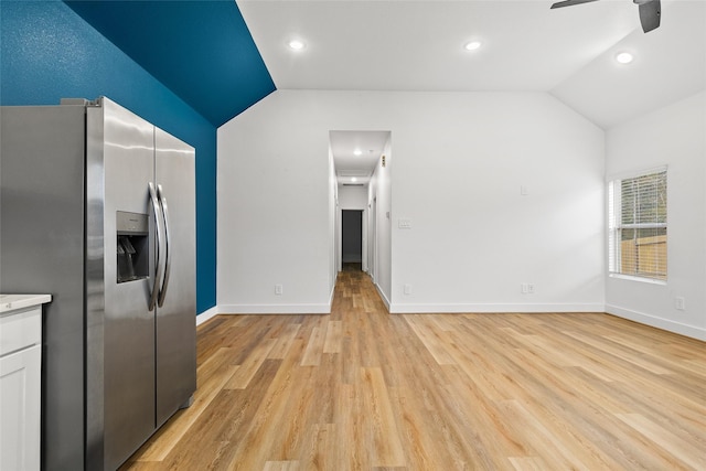 kitchen featuring lofted ceiling, stainless steel fridge with ice dispenser, white cabinets, and light wood-type flooring