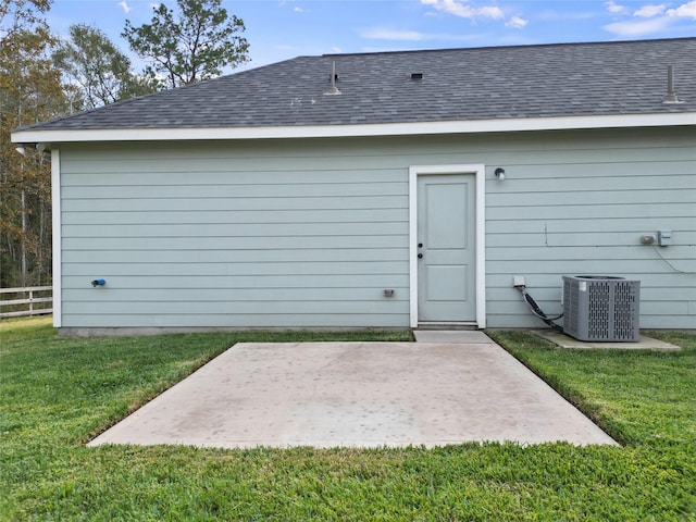 back of property with a lawn, central air condition unit, and a patio area