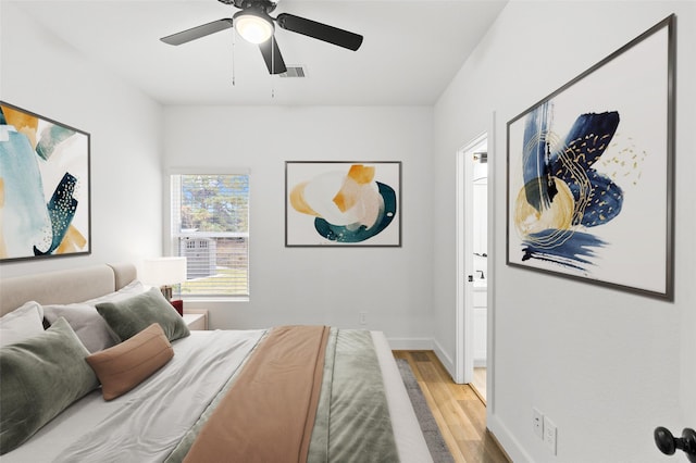 bedroom with ensuite bathroom, ceiling fan, and light hardwood / wood-style flooring