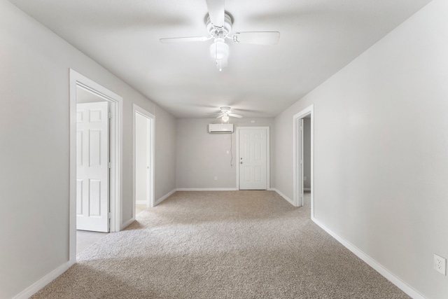 carpeted spare room with a wall mounted air conditioner and ceiling fan