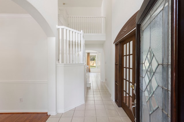 hallway with light tile patterned floors and ornamental molding