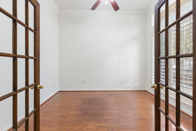 empty room featuring hardwood / wood-style flooring, crown molding, and french doors