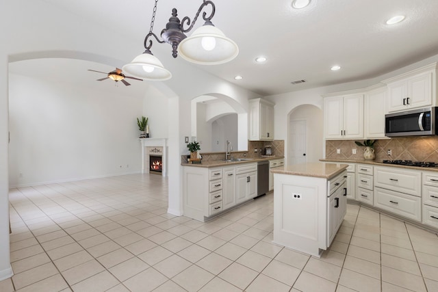 kitchen featuring pendant lighting, a center island, sink, ceiling fan, and appliances with stainless steel finishes