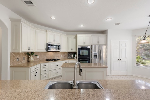 kitchen featuring decorative backsplash, sink, black appliances, light tile patterned floors, and hanging light fixtures